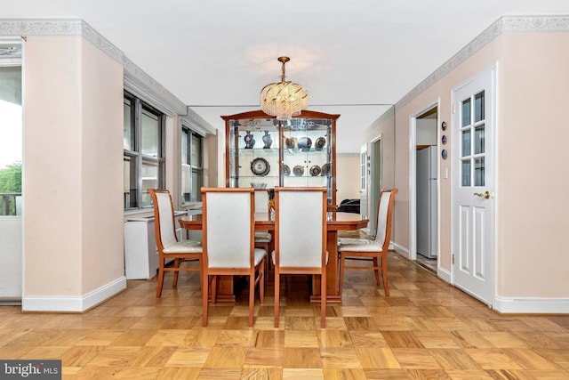 dining room featuring baseboards and a notable chandelier