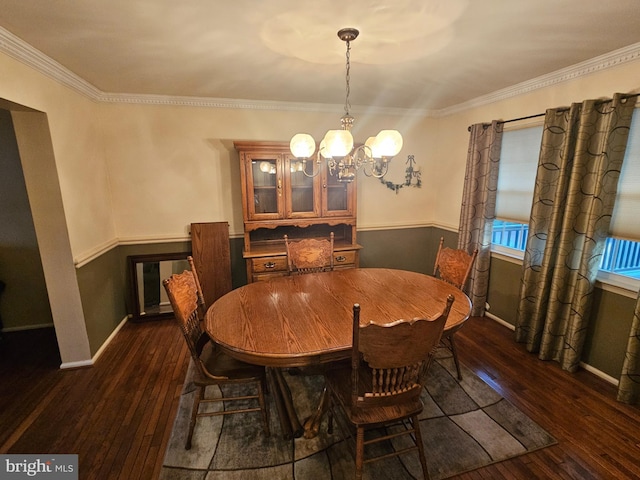 dining space with dark wood finished floors, baseboards, crown molding, and an inviting chandelier