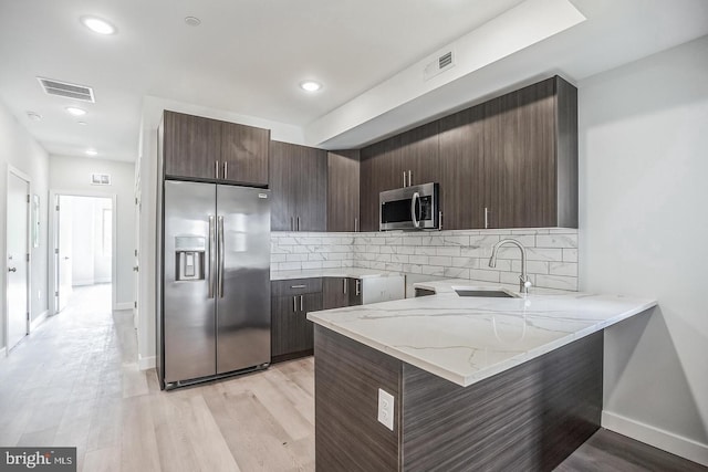 kitchen featuring dark brown cabinets, visible vents, appliances with stainless steel finishes, and a sink