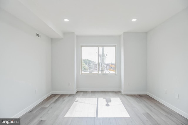 empty room featuring recessed lighting, visible vents, light wood-style flooring, and baseboards