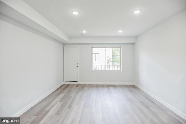 spare room with light wood finished floors, recessed lighting, and baseboards