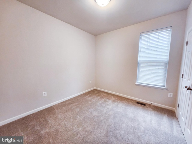 carpeted empty room featuring visible vents and baseboards