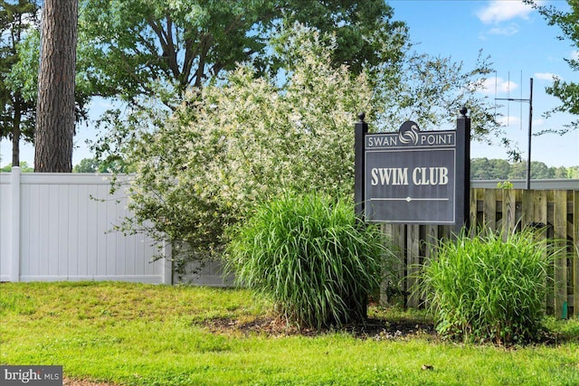 community / neighborhood sign featuring fence