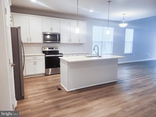 kitchen featuring tasteful backsplash, visible vents, stainless steel appliances, and a sink