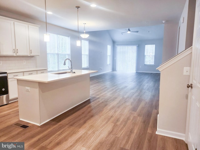 kitchen with a center island with sink, white cabinetry, a ceiling fan, and a sink