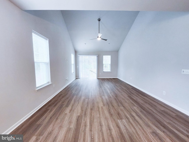 empty room featuring baseboards, high vaulted ceiling, wood finished floors, and a ceiling fan