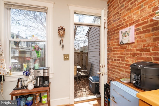 entryway featuring brick wall and a wealth of natural light