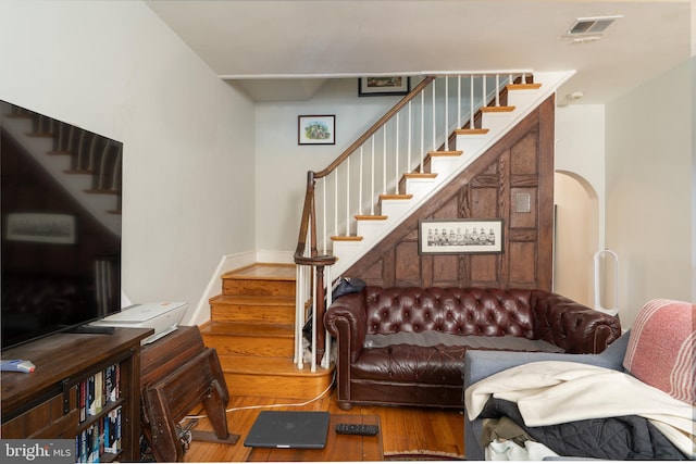 living area featuring visible vents, wood finished floors, and stairs