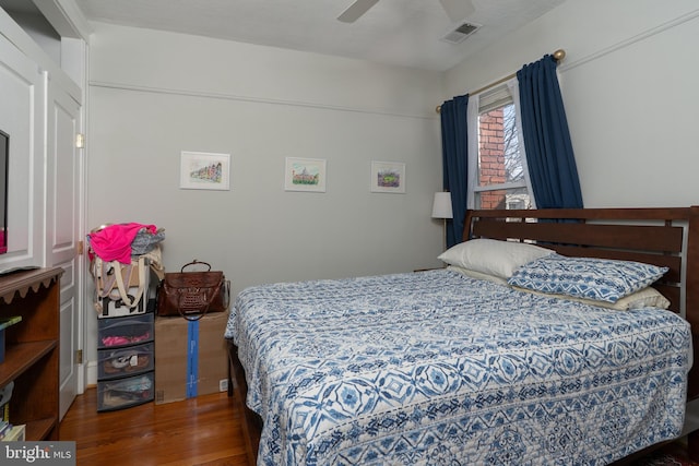 bedroom featuring wood finished floors, visible vents, and ceiling fan