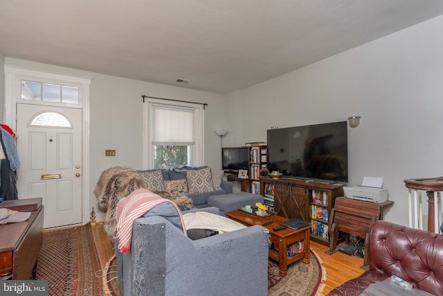 living area featuring visible vents and wood finished floors