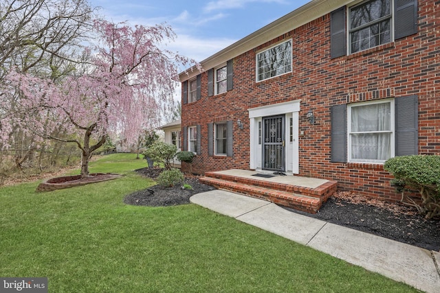 view of front of home featuring brick siding and a front yard
