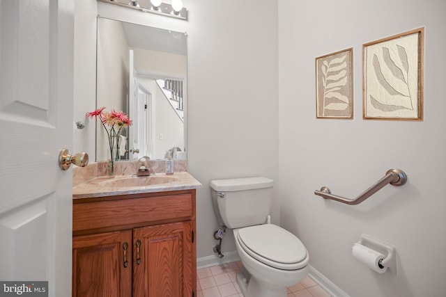 half bath with vanity, toilet, tile patterned flooring, and baseboards