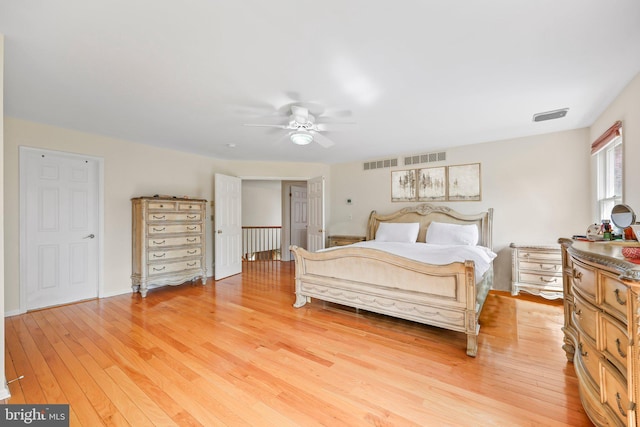 bedroom with ceiling fan, visible vents, and light wood-style flooring