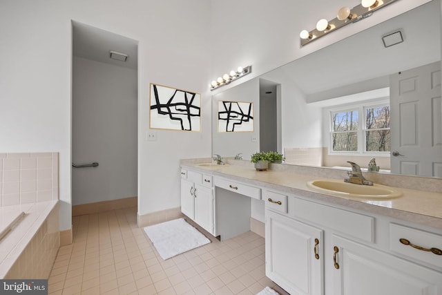 full bath with tile patterned flooring, tiled tub, a sink, and double vanity