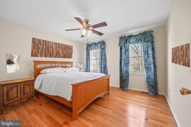 bedroom featuring ceiling fan, baseboards, and light wood-style floors