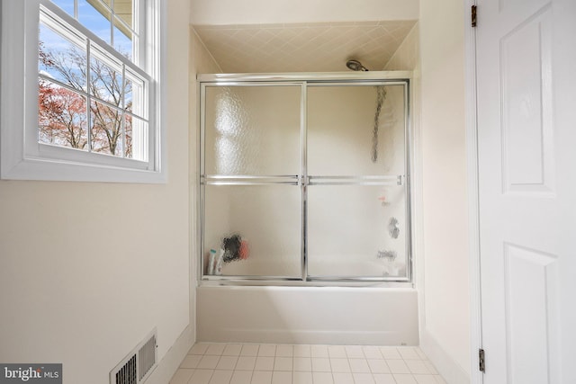 full bath with tile patterned flooring, visible vents, and combined bath / shower with glass door