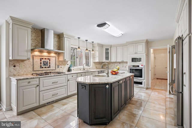 kitchen with tasteful backsplash, a warming drawer, wall chimney range hood, and stainless steel appliances