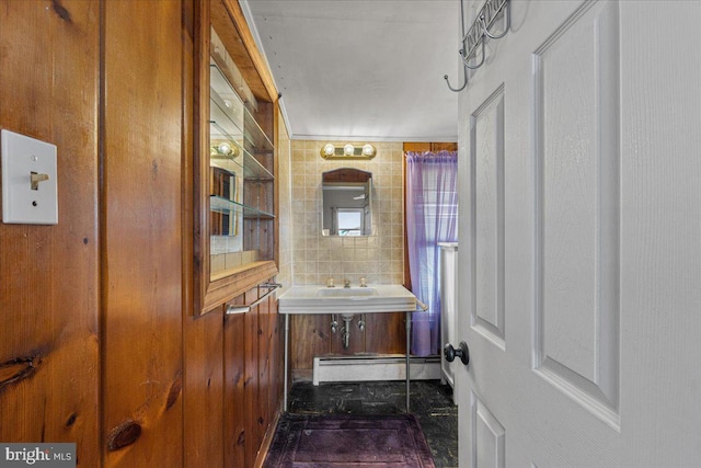 bathroom featuring a sink, tile walls, and a baseboard radiator