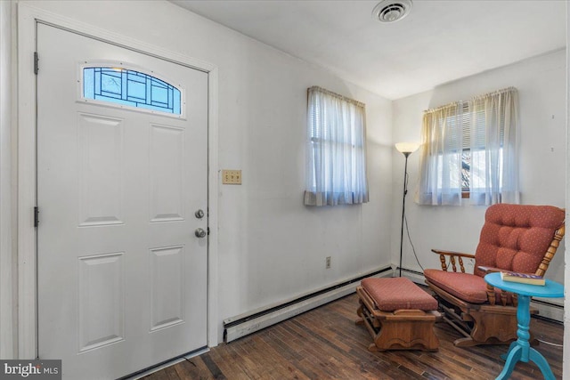 foyer entrance featuring visible vents, a baseboard radiator, and wood finished floors