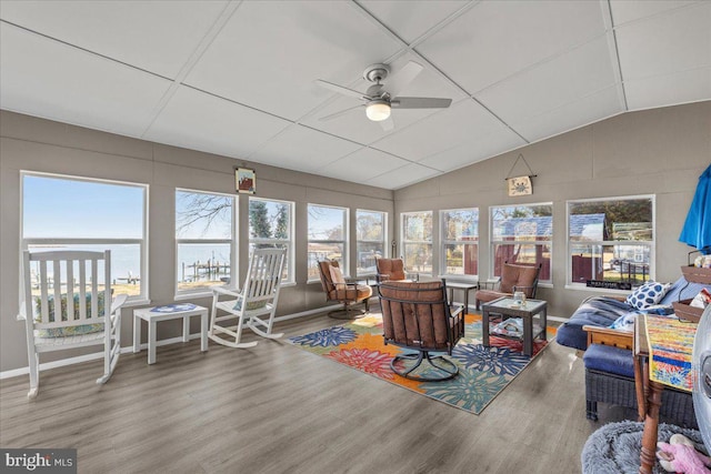 sunroom with lofted ceiling, ceiling fan, and a water view