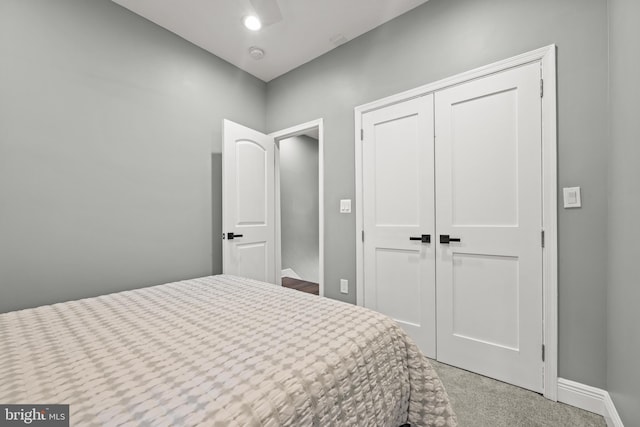 carpeted bedroom featuring a closet and baseboards