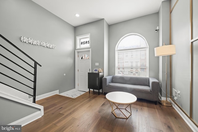 foyer featuring stairs, hardwood / wood-style flooring, and baseboards