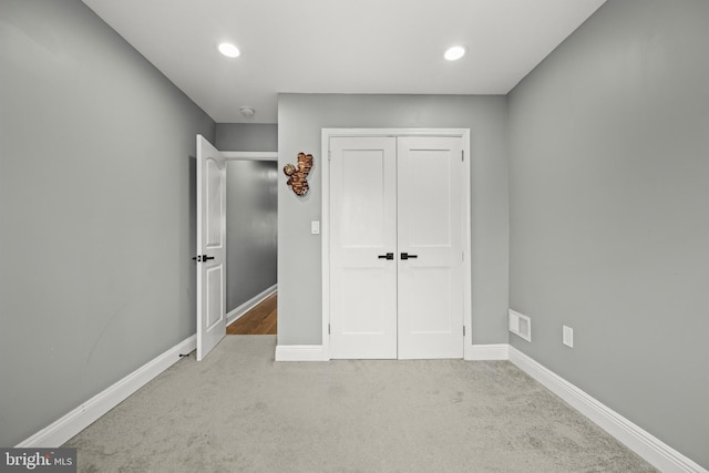 unfurnished bedroom featuring recessed lighting, carpet, baseboards, and a closet