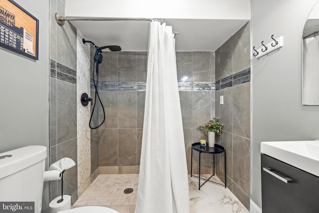 full bath with vanity, toilet, marble finish floor, and tiled shower