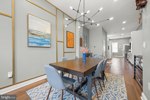 dining area with a notable chandelier, recessed lighting, baseboards, and wood-type flooring