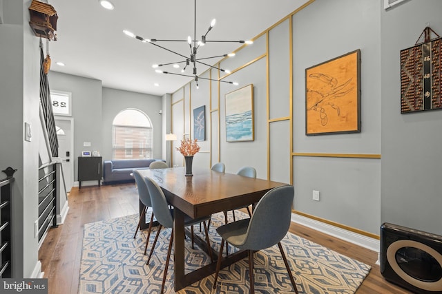 dining room with hardwood / wood-style flooring, a notable chandelier, recessed lighting, and baseboards