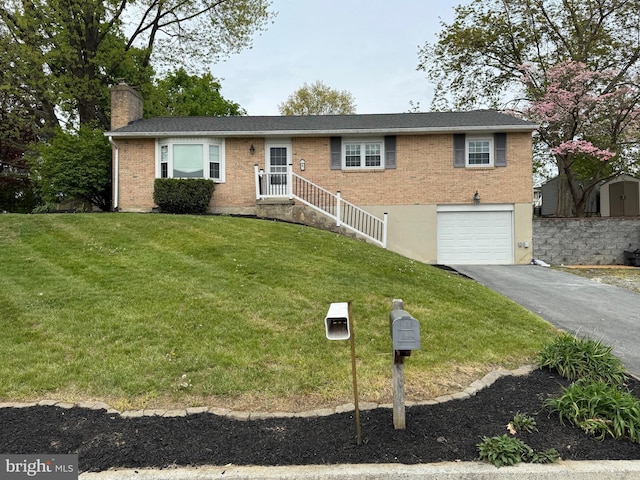 ranch-style house with a front yard, a chimney, brick siding, an attached garage, and driveway