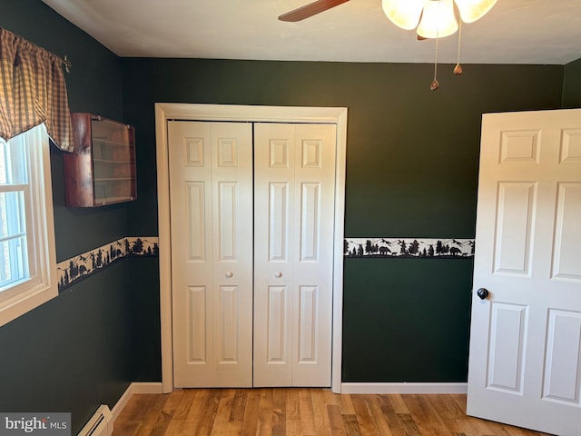 unfurnished bedroom with a closet, ceiling fan, and wood finished floors