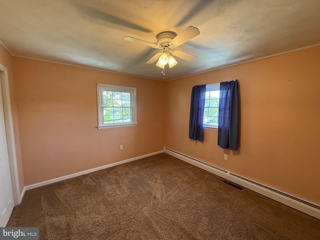 empty room featuring baseboards, a healthy amount of sunlight, dark carpet, and a baseboard radiator