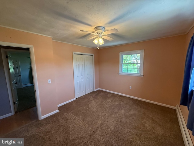 unfurnished bedroom featuring a closet, baseboards, a baseboard heating unit, a ceiling fan, and carpet