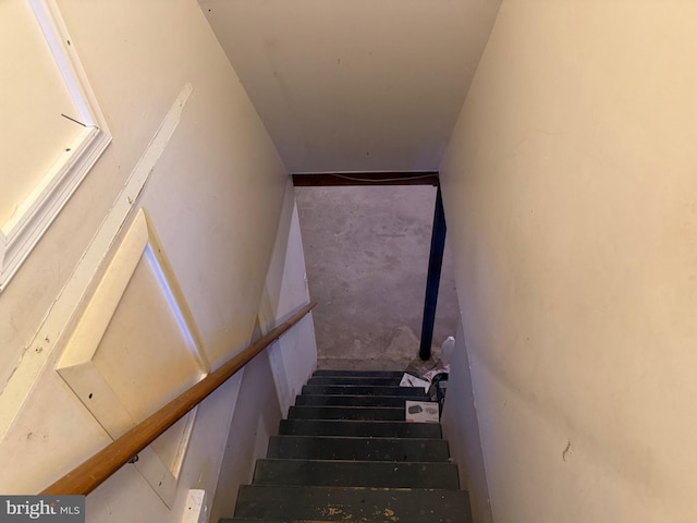 stairway with unfinished concrete flooring