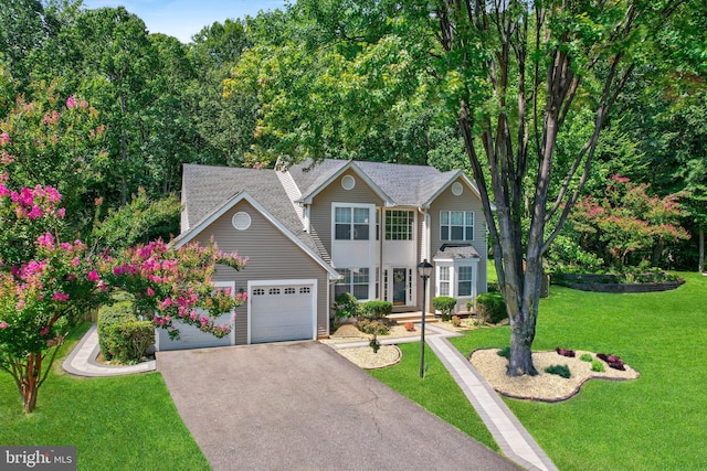view of front of house with a front lawn, a garage, and driveway