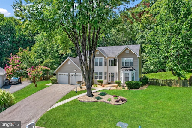 view of front of property with a front yard, fence, a shingled roof, a garage, and aphalt driveway