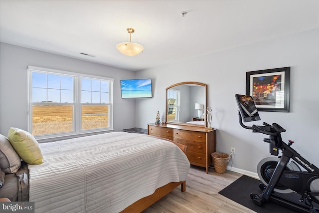 bedroom with visible vents, baseboards, and light wood-style floors