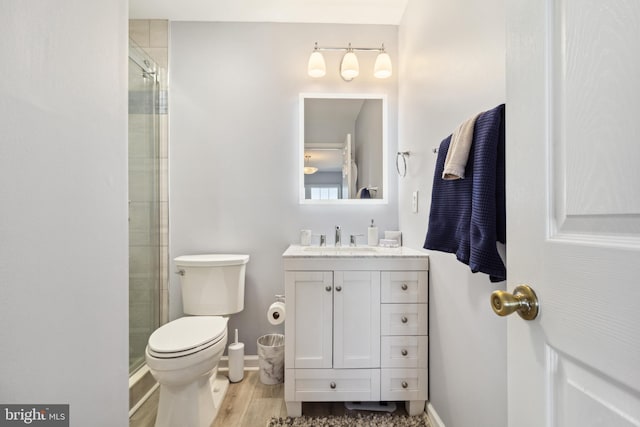 full bath with vanity, a shower stall, toilet, and wood finished floors