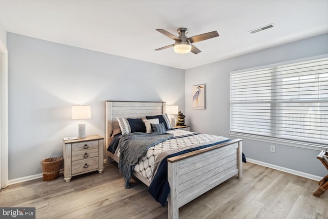 bedroom featuring visible vents, baseboards, light wood-style floors, and ceiling fan