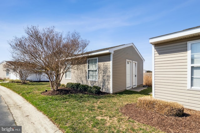 view of side of property featuring an outdoor structure and a yard