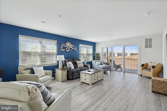 living room with visible vents and light wood-style flooring