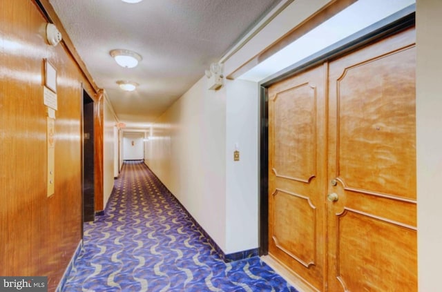 hallway featuring a textured ceiling and carpet