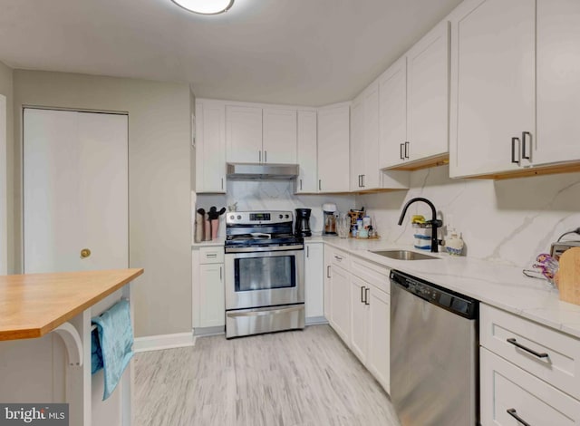 kitchen with a sink, white cabinetry, appliances with stainless steel finishes, and under cabinet range hood