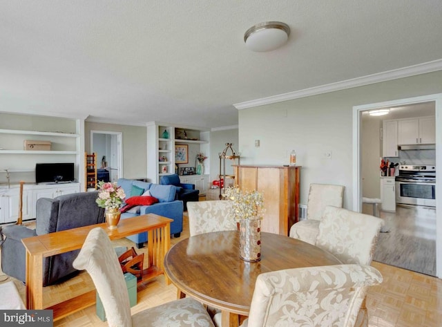 dining space featuring built in shelves, a textured ceiling, and crown molding