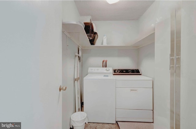 washroom with laundry area, washing machine and dryer, and a textured ceiling