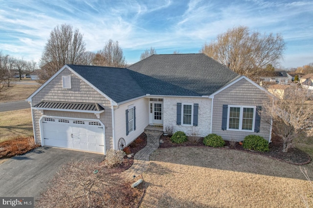 ranch-style house featuring an attached garage, driveway, and roof with shingles