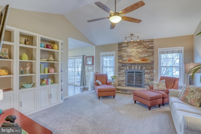 living area featuring vaulted ceiling, carpet flooring, a wealth of natural light, and ceiling fan