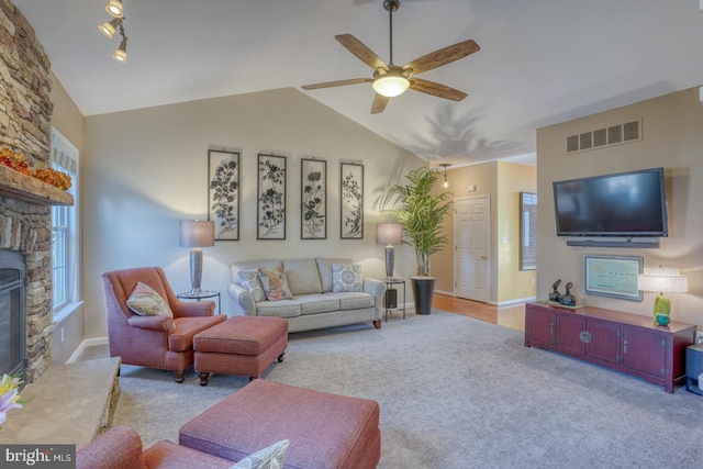 carpeted living area featuring lofted ceiling, baseboards, visible vents, and ceiling fan