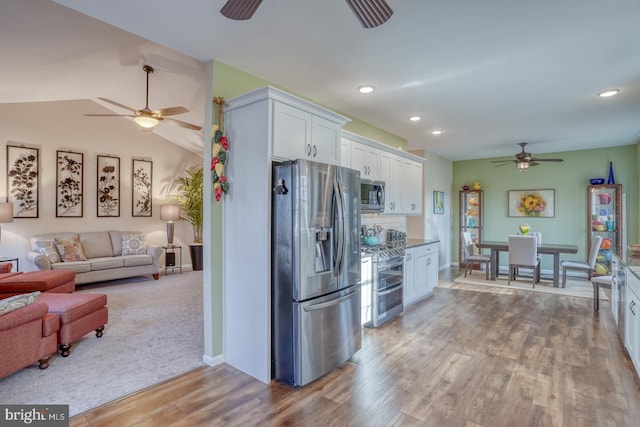 kitchen featuring tasteful backsplash, wood finished floors, white cabinetry, appliances with stainless steel finishes, and ceiling fan